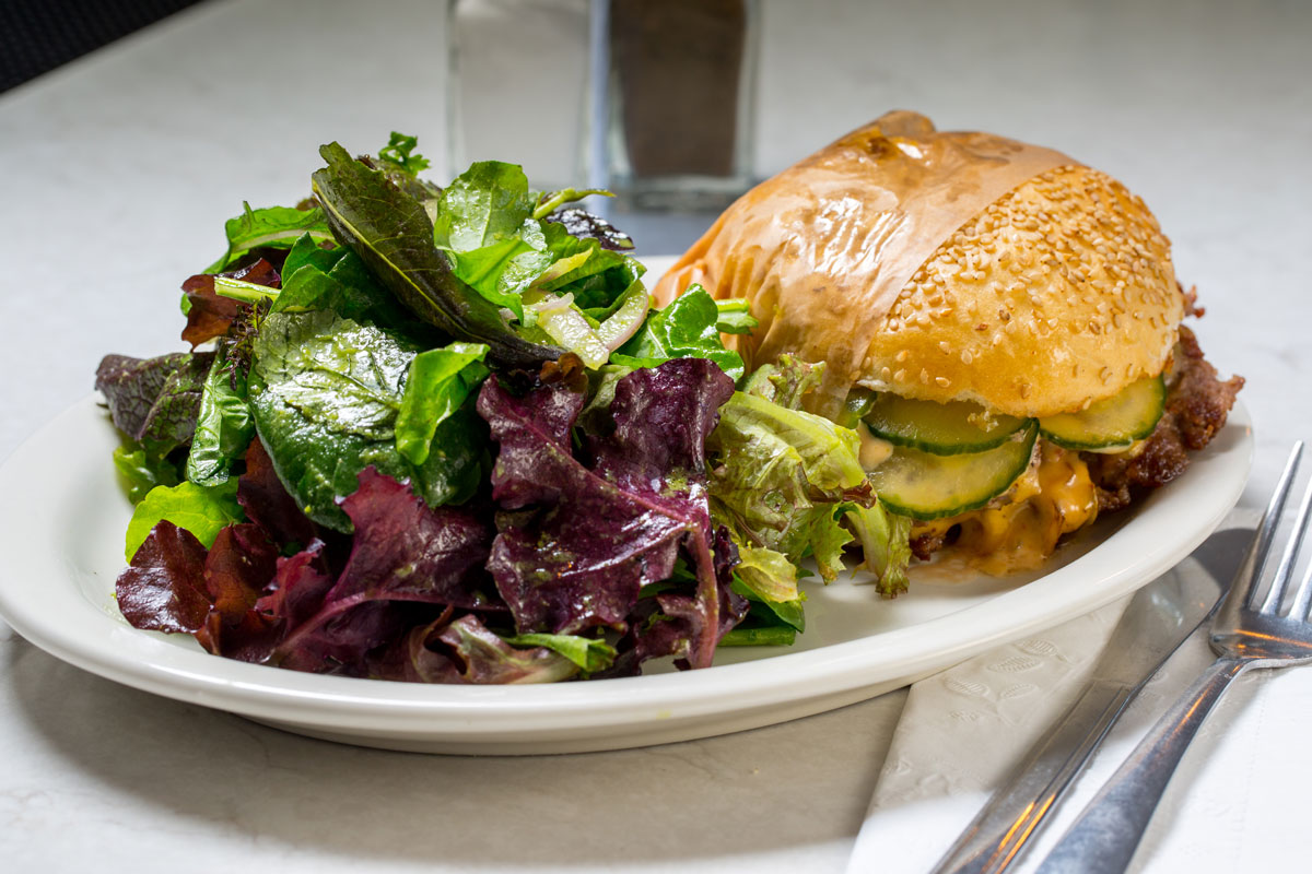 Gracie’s fried chicken sandwich with pickles and a green salad